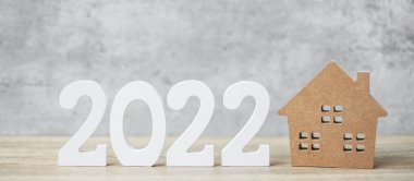 2022 mutlu yıllar. Masada ev modeli var. Bankacılık, gayrimenkul, yatırım, finans, tasarruf ve yeni yıl kararı kavramları