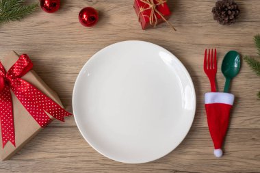Tabak, çatal ve kaşıkla tahta masa arkaplanlı mutlu Noeller. Xmas, parti ve mutlu yıllar konsepti.