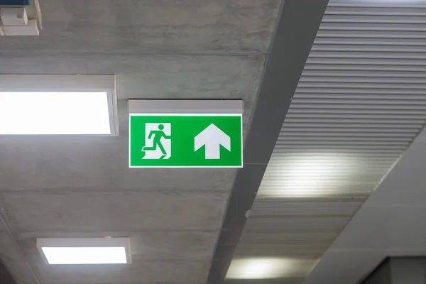 Fire Emergency exit sign on the wall inside building at subway train station. Safety concept
