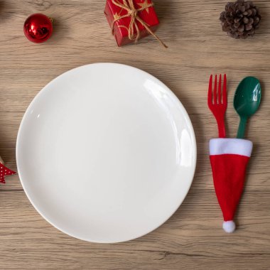 Tabak, çatal ve kaşıkla tahta masa arkaplanlı mutlu Noeller. Xmas, parti ve mutlu yıllar konsepti.