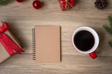 Boş defter, sade kahve fincanı ve Noel hediyesi ahşap masa, üst manzara ve fotokopi odası. Xmas, Mutlu Yıllar, Hedefler, Kararlılık, Yapılacaklar listesi, Strateji ve Planlama konsepti