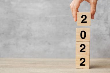 Masanın üzerinde el ele tutuşma bloğu 2022 metin. Çözüm, strateji, plan, hedef, motivasyon, yeniden başlatma, iş ve yeni yıl tatili kavramları