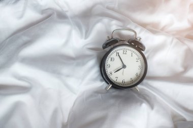 Yataktaki klasik çalar saat ve mesaj için de yeri kopyala. Uyanın, uyku, günlük rutin, sabah, egzersiz ve iş hayatı dengesi kavramı