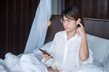 Happy woman using smart phone for video call, female meeting  online by mobile phone on bed. technology, network, work frome home, lifestyle and digital communication concept