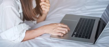 İş için dizüstü bilgisayar kullanan mutlu bir kadın. Yatakta bilgisayarla buluşan bir kadın. teknoloji, ağ, evden çalışma, yaşam tarzı ve dijital iletişim kavramı