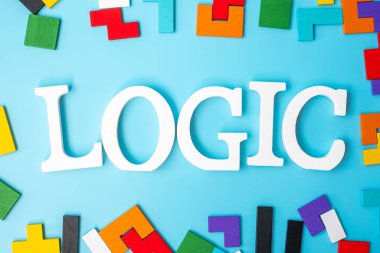 Renkli ahşap yapboz parçaları içeren lojik metin, mavi arkaplanda geometrik şekil bloğu. Mantıksal düşünme kavramları, Conundrum, çözümler, rasyonel, strateji, dünya mantık günü ve eğitim