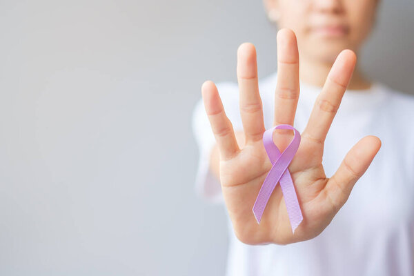 World cancer day (February 4). Woman hand holding Lavender purple ribbon for supporting people living and illness. Healthcare and medical concept
