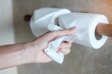 Tuvalette tuvalet kağıdı çeken bir kadın. Temizlik, yaşam tarzı ve kişisel temizlik konsepti