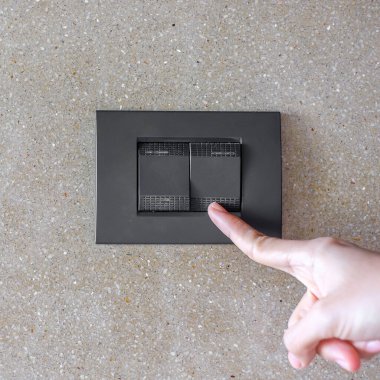 Evdeki duvardaki ışık düğmesini aç ya da kapat. Enerji tasarrufu, güç, elektrik ve yaşam tarzı kavramları