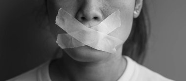 Ağzı yapışkan bantla mühürlenmiş kadın. İfade özgürlüğü, basın özgürlüğü, İnsan hakları, Protesto diktatörlüğü, demokrasi, özgürlük, eşitlik ve kardeşlik kavramları