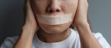 Ağzı yapışkan bantla mühürlenmiş kadın. İfade özgürlüğü, basın özgürlüğü, İnsan hakları, Protesto diktatörlüğü, demokrasi, özgürlük, eşitlik ve kardeşlik kavramları