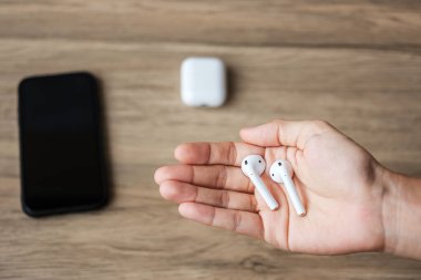 Akıllı telefonla kullanmak için beyaz kablosuz kulaklık ya da kulaklık. Teknoloji konsepti