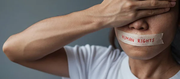 woman with mouth sealed in adhesive tape with Human rights message. Free of speech, freedom of press, Protest dictatorship, democracy, liberty, equality and fraternity concepts