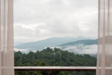 Beautiful mountain view with balcony and window curtain at countryside home or homestay in the morning