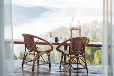 arabica coffee brewing by Vintage coffee drip equipment set on wooden table in the morning with mountain at countryside homestay 