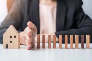 İşadamı tahta bloklardan düşmeyi bırak ve ev modelini koru. Kriz, Sonbahar İşletmeleri, Risk, Ekonomik durgunluk, Geliştirici, Gayrimenkul ve Gayrimenkul kavramı