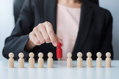 İş kadını eli, işçi kalabalığından lider ahşabı çekiyor. Toksik İnsanlar, İnsan Kaynakları Yönetimi, İşe Alma, Takım Çalışması ve Liderlik Konseptleri