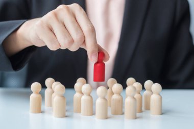 İş kadını eli, işçi kalabalığından lider ahşabı çekiyor. Toksik İnsanlar, İnsan Kaynakları Yönetimi, İşe Alma, Takım Çalışması ve Liderlik Konseptleri