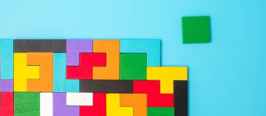 Mavi arka planda renkli ahşap yapboz parçaları, geometrik şekil bloğu. Mantıksal düşünme kavramları, Conundrum, çözümler, rasyonel, strateji, dünya mantık günü ve eğitim