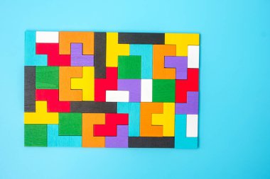 Mavi arka planda renkli ahşap yapboz parçaları, geometrik şekil bloğu. Mantıksal düşünme kavramları, Conundrum, çözümler, rasyonel, strateji, dünya mantık günü ve eğitim