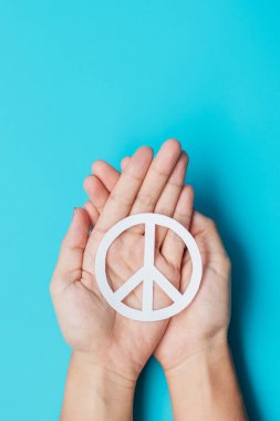 Uluslararası Barış Günü. Mavi arka planda beyaz kağıt, barış sembolü tutan eller. Özgürlük, Umut, Dünya Barışı Günü 21 Eylül ve Nükleer Silahsızlanma Kavramları..