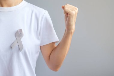 Beyin kanseri farkındalığı ayı, yaşayan insanları desteklemek için gri renkli kurdele. Sağlık ve Dünya Kanser Günü konsepti