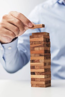 Yerleştirme veya ahşap blok kule çekerek işadamı el. İş planlama, Risk Yönetimi, çözüm ve strateji kavramları
