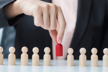 İş kadını eli, işçi kalabalığından lider ahşabı çekiyor. Toksik İnsanlar, İnsan Kaynakları Yönetimi, İşe Alma, Takım Çalışması ve Liderlik Konseptleri