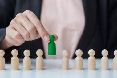 İş kadını eli, işçi kalabalığından lider ahşabı çekiyor. Toksik İnsanlar, İnsan Kaynakları Yönetimi, İşe Alma, Takım Çalışması ve Liderlik Konseptleri