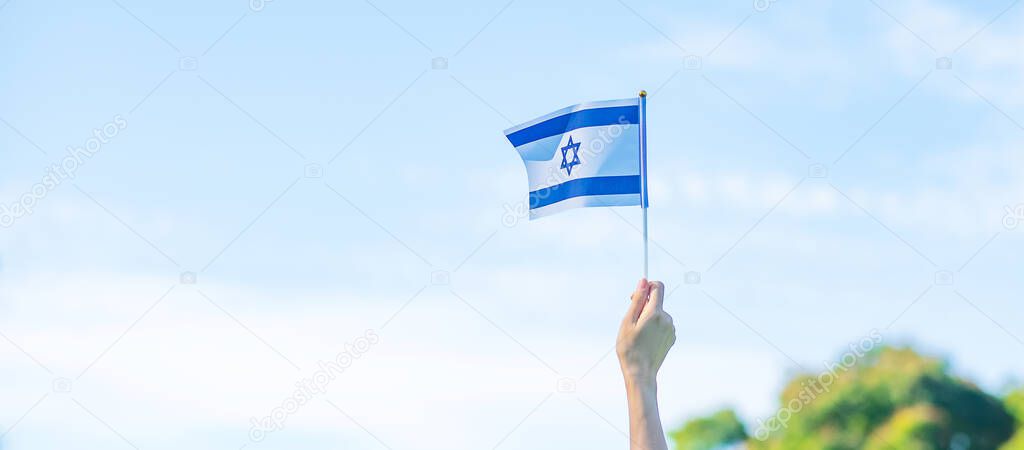 hand holding Israel flag on nature background. Israel Independence day and happy celebration concepts