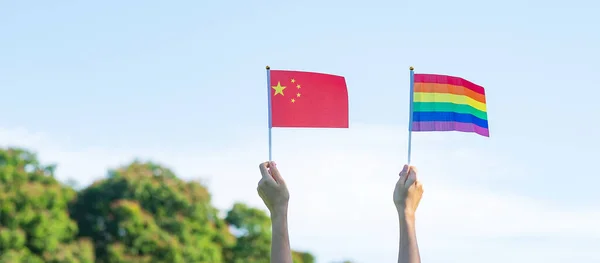 自然を背景にLgbtqレインボーと中国の旗を見せる手 サポートレズビアン バイセクシャル トランスジェンダー クィアコミュニティとプライド月間のコンセプト — ストック写真