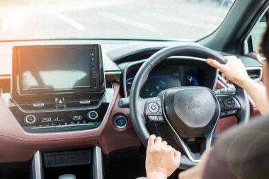 Kadın sürücü yolda araba kullanıyor, elektrikli modern otomobilde el kontrollü direksiyon. Yolculuk, yolculuk ve güvenlik ulaşım kavramları