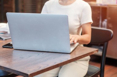 Casual Businesswoman using laptop, freelance woman typing keyboard computer notebook in cafe or modern office. technology, digital online and network concept