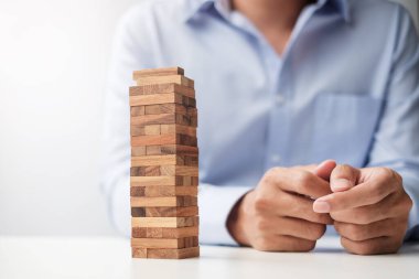 Yerleştirme veya ahşap blok kule çekerek işadamı el. İş planlama, Risk Yönetimi, çözüm ve strateji kavramları
