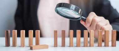 İş kadını, blok kalabalığından tahtadan adam toplamak için büyüteç taşıyor. İnsan kaynakları yönetimi, işe alım, takım çalışması, işe alım ve liderlik kavramları