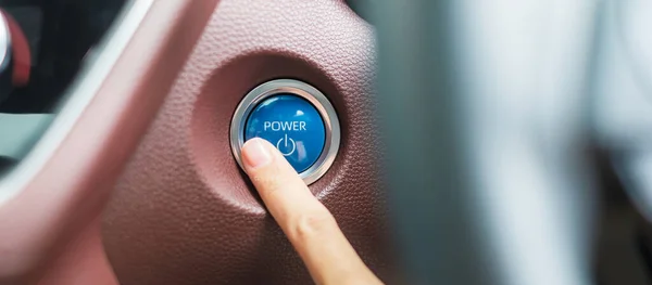 Finger press a car ignition button or START engine inside modern electric automobile. Keyless, change, strategy, vision, innovation and future concept