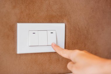 Evdeki duvardaki ışık düğmesini aç ya da kapat. Enerji tasarrufu, güç, elektrik ve yaşam tarzı kavramları