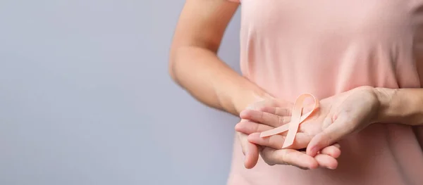 Frau Hält Pfirsichband Für Den Monat September Uterine Cancer Awareness — Stockfoto