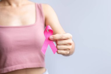 Pink October Breast Cancer Awareness month, woman hand hold pink Ribbon and wear shirt for support people life and illness. National cancer survivors month, Mother and World cancer day concept