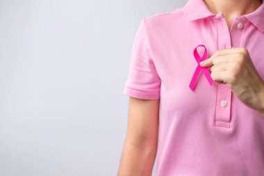 Pink October Breast Cancer Awareness month, woman hand hold pink Ribbon and wear shirt for support people life and illness. National cancer survivors month, Mother and World cancer day concept