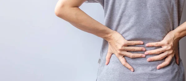灰色の背景に筋肉痛の成人女性 Piriformis症候群 脊髄圧迫により腰痛を持つ高齢女性 オフィス症候群と医療の概念 — ストック写真