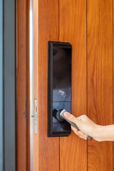 man holding handle of smart digital door lock while open or close the door. Technology, electrical and lifestyle concepts