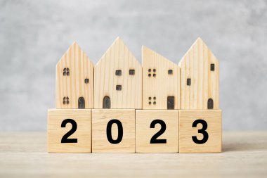 2023 Happy New Year with house model on table. Banking, real estate, investment, financial, savings and New Year Resolution concepts