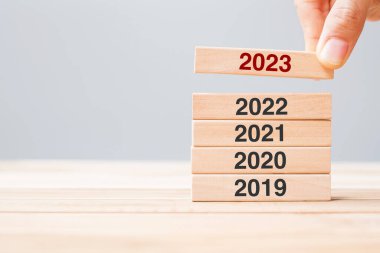2023 block over 2022 and 2021 wooden building on table background. Business planning, Risk Management, Resolution, strategy, solution, goal, New Year New You and happy holiday concepts