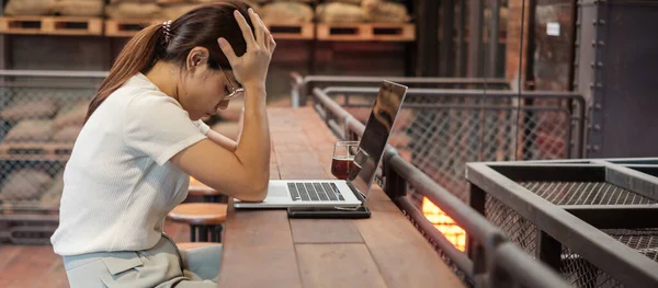 Casual businesswoman serious and concerned with laptop computer, asian woman stressed and tired from work in workspace or cafe. busy business, workload and unhappy concept