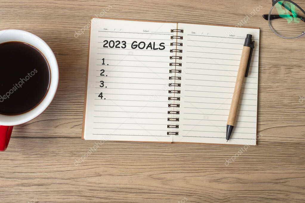2023 GOAL with notebook, black coffee cup and pen on wood table, Top view and copy space. Happy New Year, Resolution, To do list, Strategy and Plan concept