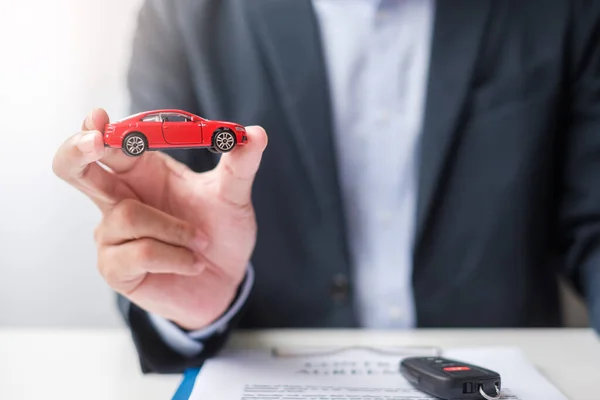 Üzletember Kéz Kezében Piros Autó Játék Jármű Kulcs Nélkül Toll — Stock Fotó