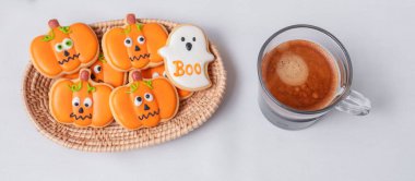 Sıcak espresso kahvesi ya da komik Cadılar Bayramı kurabiyeleriyle çikolata fincanı. Mutlu Cadılar Bayramı, Trick or Threat, Hello October, güz, geleneksel, parti ve tatil konsepti