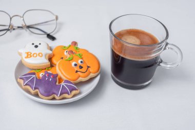 Sıcak espresso kahvesi ya da komik Cadılar Bayramı kurabiyeleriyle çikolata fincanı. Mutlu Cadılar Bayramı, Trick or Threat, Hello October, güz, geleneksel, parti ve tatil konsepti
