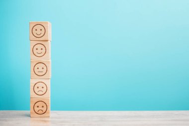 Mavi arka planda duygusal yüz blokları. Hizmet derecesi, sıralama, müşteri değerlendirmesi, memnuniyet, değerlendirme ve geri bildirim kavramı